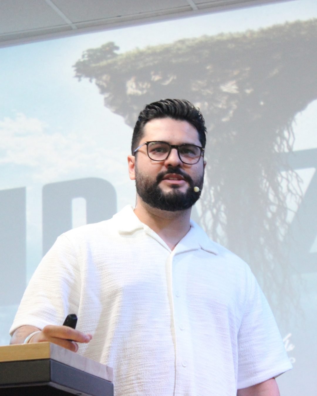 Pastor Thomas Abelini pregando ao púlpito, de camisa branca